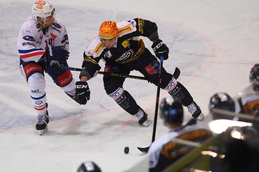 From left, Zurich&#039;s player Chris Baltisberger, fight for the puck with Ambri&#039;s Top Scorer Matt D&#039;Agostini, during the preliminary round game of National League A (NLA) Swiss Championshi ...
