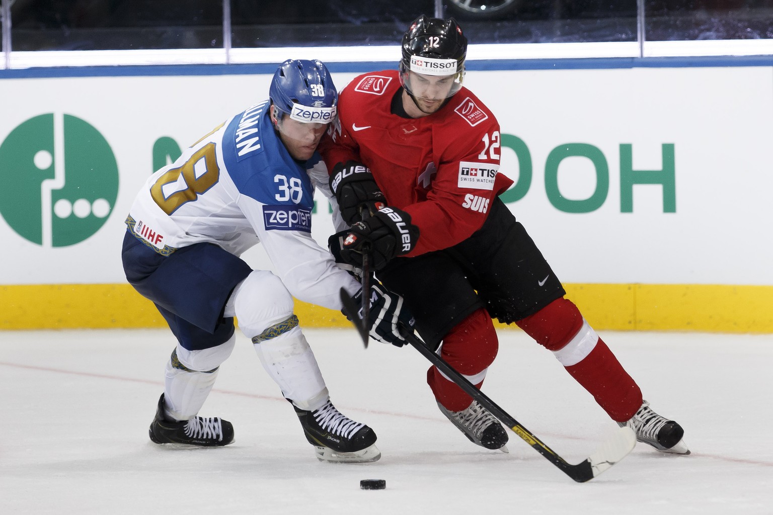 Kazakhstan&#039;s Kevin Dallman, left, vies for the puck with Switzerland&#039;s Luca Cunti, right, during the 2014 IIHF Ice Hockey World Championships preliminary round game Switzerland vs Kazakhstan ...