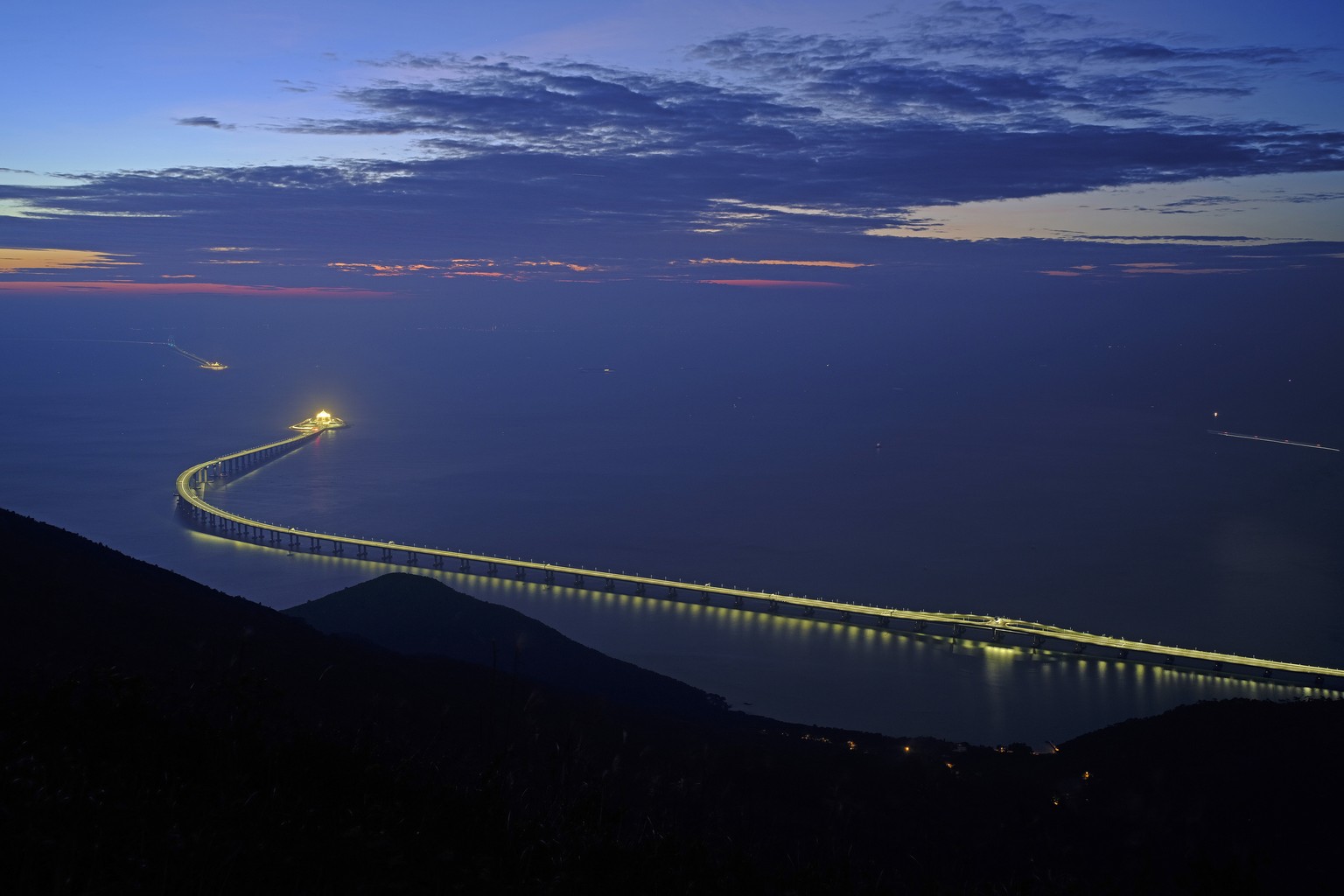 In this Sunday, Oct. 21, 2018, photo, the Hong Kong-Zhuhai-Macau Bridge is lit up in Hong Kong. The bridge, the world&#039;s longest cross-sea project, which has a total length of 55 kilometers (34 mi ...