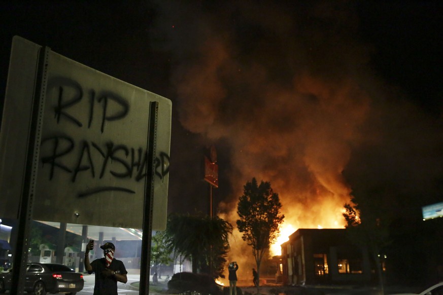&quot;RIP Rayshard&quot; is spray painted on a sign as as flames engulf a Wendy&#039;s restaurant during protests Saturday, June 13, 2020, in Atlanta. The restaurant was where Rayshard Brooks was shot ...
