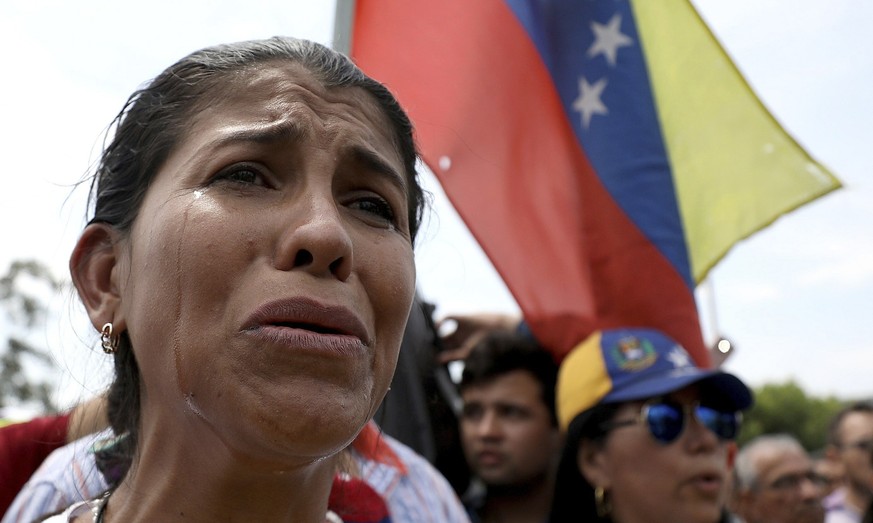 Venezuelan migrant Yanela Aleman cries as she sings her national anthem in La Parada, near Cucuta, Colombia, on the border with Venezuela, Sunday, Feb. 17, 2019. As part of U.S. humanitarian aid to Ve ...