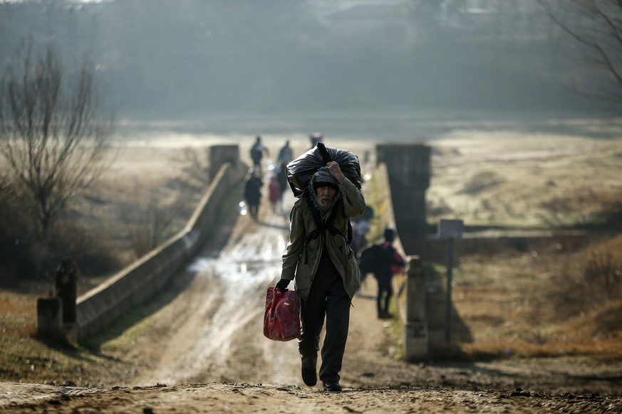 Migrants walk to enter Greece from Turkey by crossing the Maritsa river (Evros river in Greek) near the Pazarkule border gate in Edirne, Turkey, Sunday, March. 1, 2020. The United Nations migration or ...