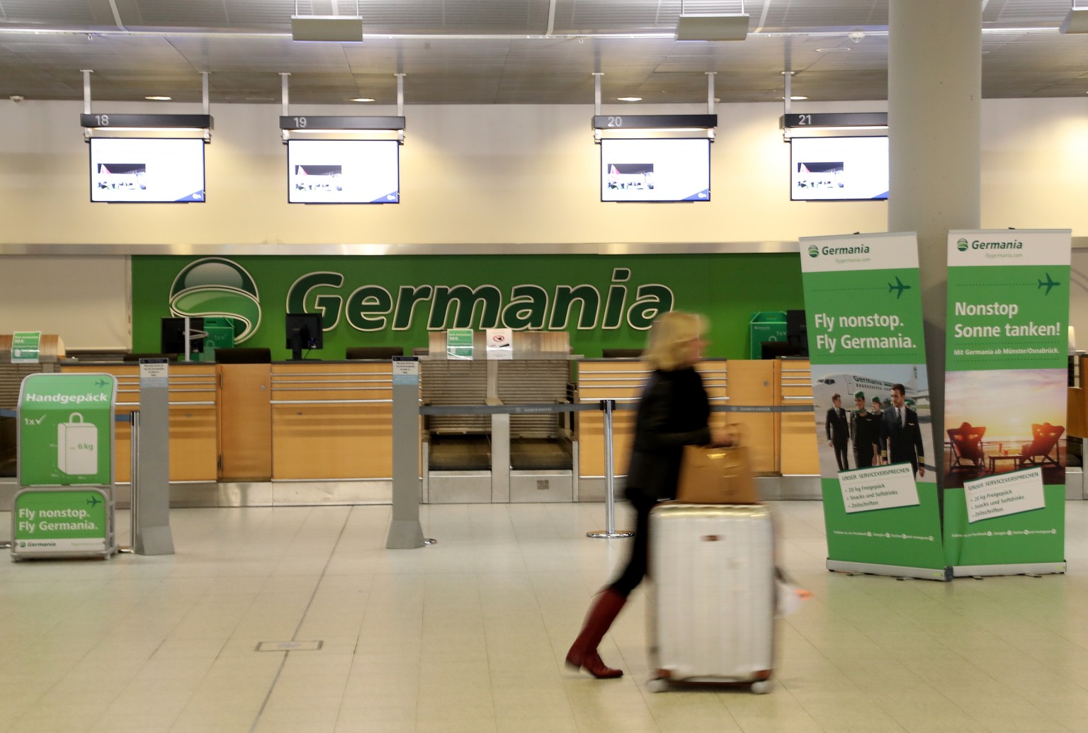 epa07345430 A passenger walks past an empty check in counter of Germania airline at the Muenster/Osnabrueck airport in Greven Germany, 05 February 2019. Germania Airlines filed for bankruptcy on 04 Fe ...