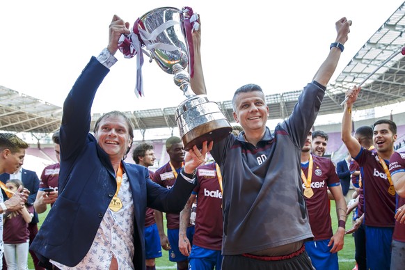 Alain Geiger, left, coach of Servette FC, and Bojan Dimic, right, assistant coach of Servette FC, lift the championship trophy after winning the Swiss Challenge League Championship, at the Challenge L ...