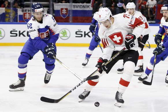 Slovakia&#039;s defender Christian Jaros, left, vies for the puck with Switzerland&#039;s forward Damien Riat, right, during the IIHF 2018 World Championship preliminary round game between Slovakia an ...