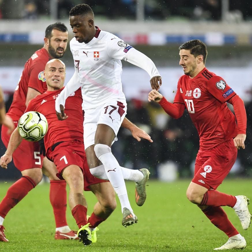 Georgia&#039;s Jaba Kankava, left, and Georgia&#039;s Jano Ananidze right, fight for the ball with Switzerland&#039;s midfielder Denis Zakaria, center, during the UEFA Euro 2020 qualifying Group D soc ...