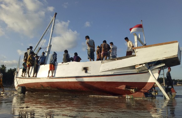 Residents inspect the wreckage of Arim Jaya, a boat that sank off Madura island, in Sumenep, Indonesia, Tuesday, June 18, 2019. Indonesian police say the overloaded passenger boat capsized after being ...