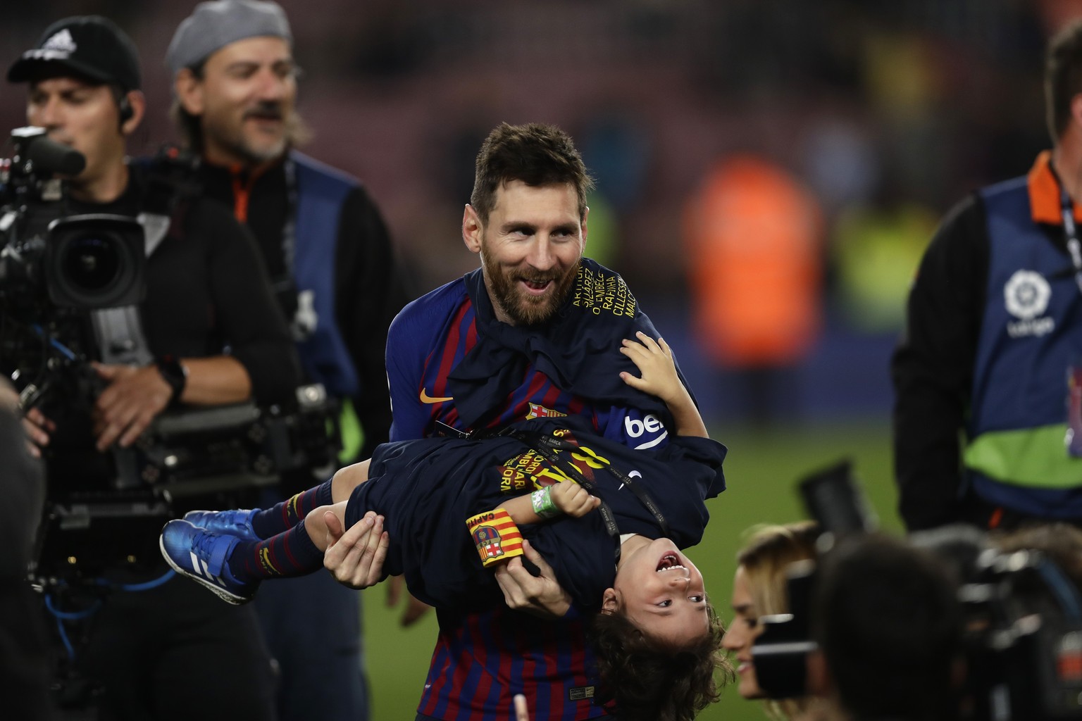 Barcelona forward Lionel Messi celebrates with his son after winning the Spanish League title, at the end of the Spanish La Liga soccer match between FC Barcelona and Levante at the Camp Nou stadium i ...