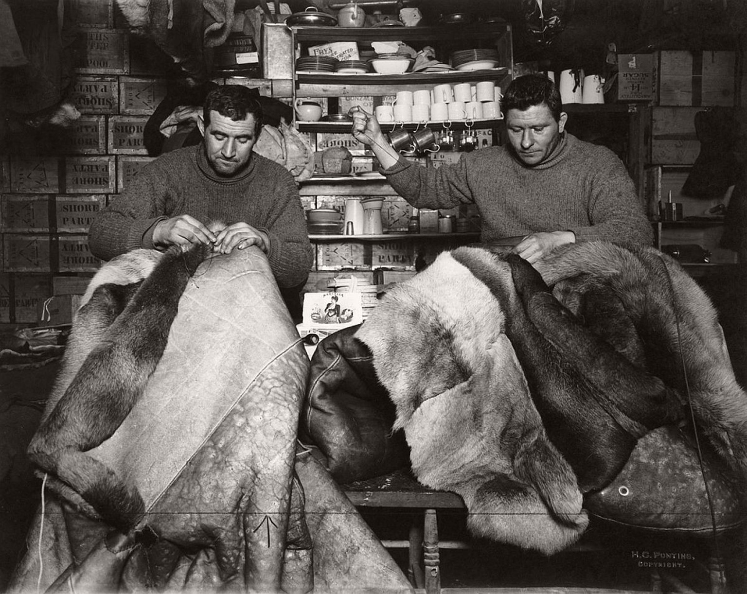 Expeditionsteilnehmer reparieren am 16. Mai 1911 Rentierfell-Schlafsäcke in der Terra-Nova-Hütte. Für die Reise zum Südpol trugen die Männer warme Stiefel aus Rentierfell, die «Finnen» genannt wurden, ...