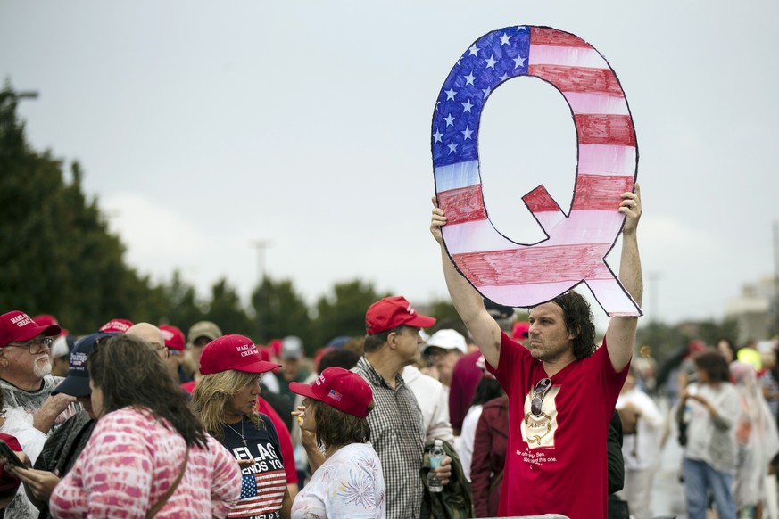 FILE - In this Aug. 2, 2018, file photo, a protesters holds a Q sign waits in line with others to enter a campaign rally with President Donald Trump in Wilkes-Barre, Pa. Candidates engaging with the Q ...