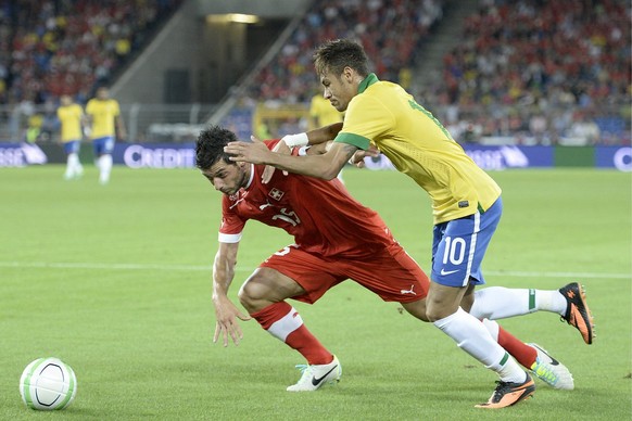 Switzerland&#039;s Blerim Dzemaili, left, fights for the ball against Brazil&#039;s Neymar, right, during a test soccer match between Switzerland and Brazil at the St. Jakob-Park stadium in Basel, Swi ...