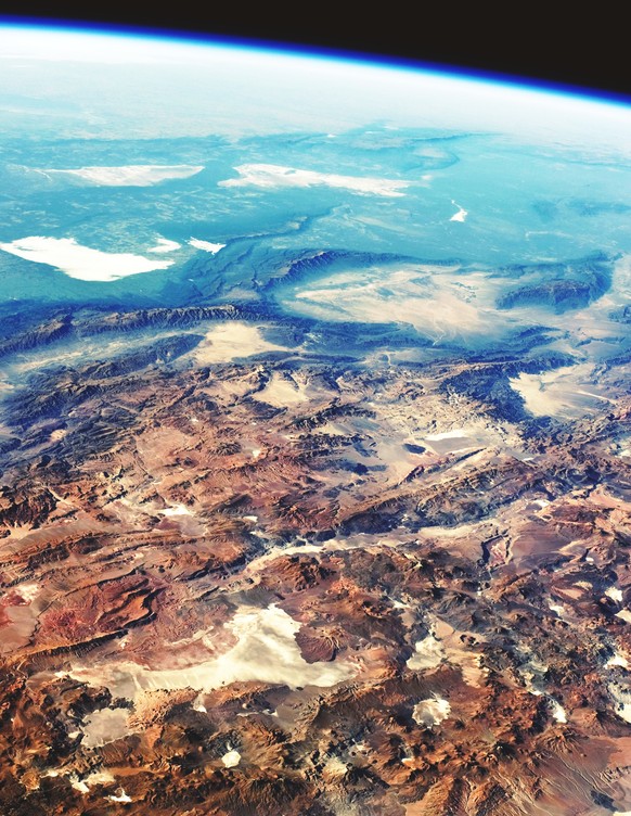 Eine Astronauten-Fotografie der Hochebenen in den Gebirgen der Anden im Hintergrund. Vorne ist die Atacama-Wüste zu sehen, von einer Reihe kleiner Vulkane umgeben