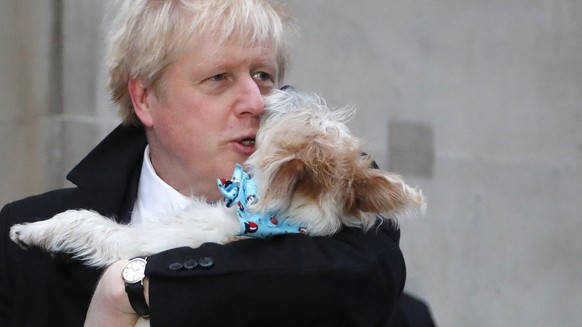 Britain&#039;s Prime Minister and Conservative Party leader Boris Johnson holds his dog Dilyn as he leaves after voting in the general election at Methodist Central Hall, Westminster, London, Thursday ...