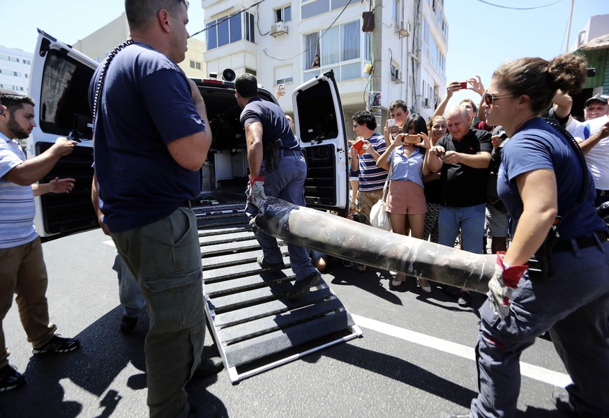 Polizisten transportieren Überreste eines Geschosses, das von der israelischen Raketenabwehr abgefangen wurde.