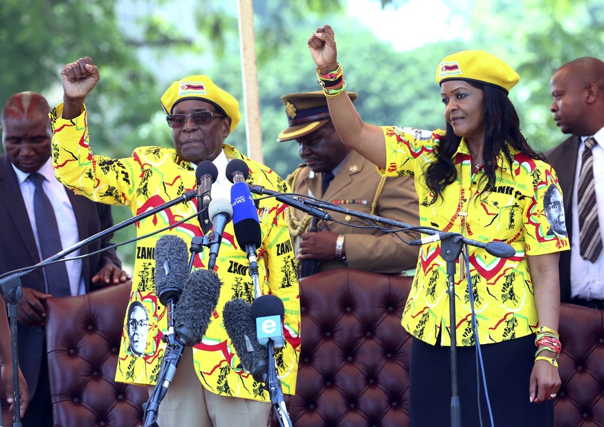 FILE - In this Nov. 8, 2017, file photo, Zimbabwe&#039;s President Robert Mugabe, left, and his wife Grace Mugabe chant the party&#039;s slogan during a solidarity rally in Harare, Zimbabwe. Zimbabwe& ...