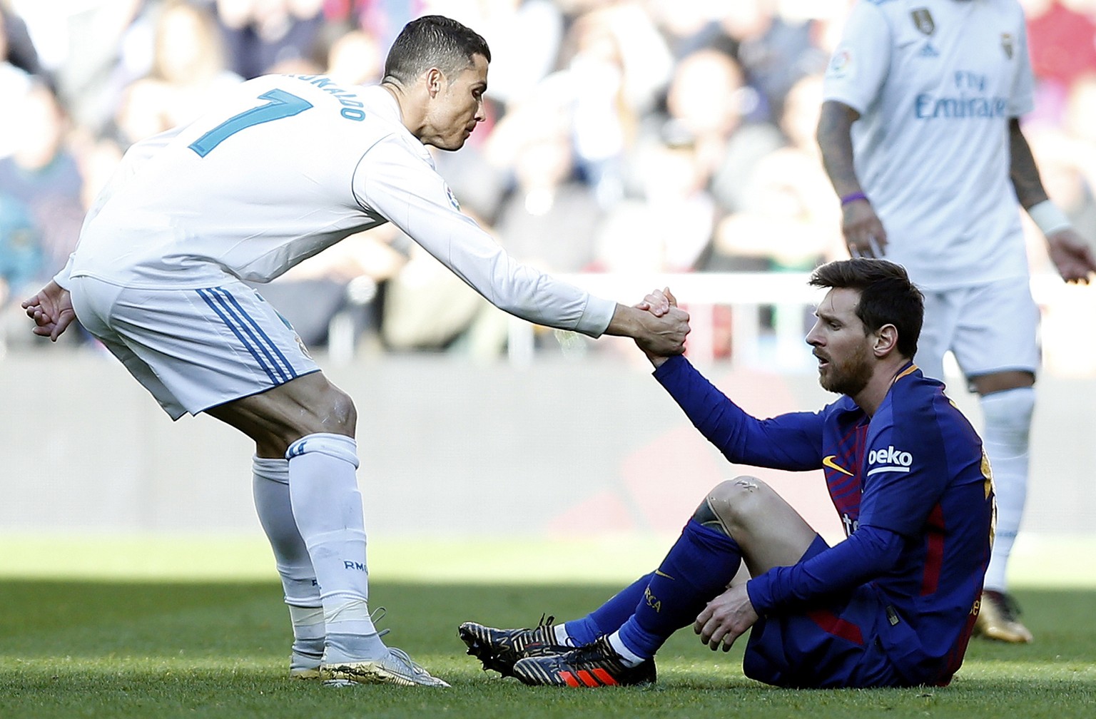 Real Madrid&#039;s Cristiano Ronaldo, left, helps Barcelona&#039;s Lionel Messi get back on his feet during the Spanish La Liga soccer match between Real Madrid and Barcelona at the Santiago Bernabeu  ...
