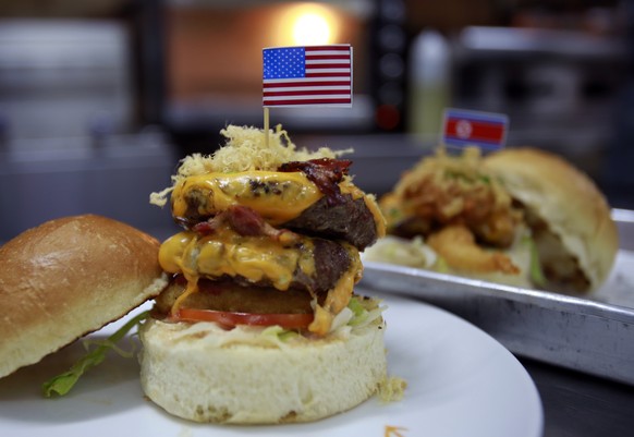 In this Feb. 24, 2019, photo, a &quot;Durty Donald&quot; and a &quot;Kim Jong Yum&quot; - Trump and Kim inspired burgers are freshly made in a restaurant in Hanoi, Vietnam. The summit this week betwee ...