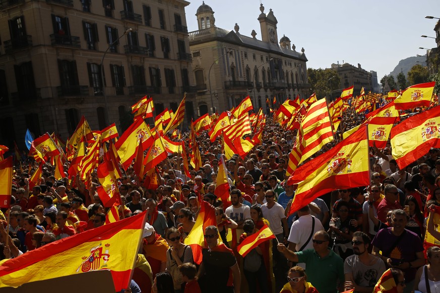 People wave Spanish and Catalan flags during a march in downtown Barcelona, Spain, to protest the Catalan government&#039;s push for secession from the rest of Spain, Sunday Oct. 8, 2017. Sunday&#039; ...