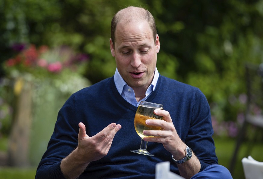 Britain&#039;s Prince William drinks cider during a visit to The Rose and Crown pub in Snettisham, England, Friday July 3, 2020. English pubs are among the businesses that are allowed to welcome guest ...