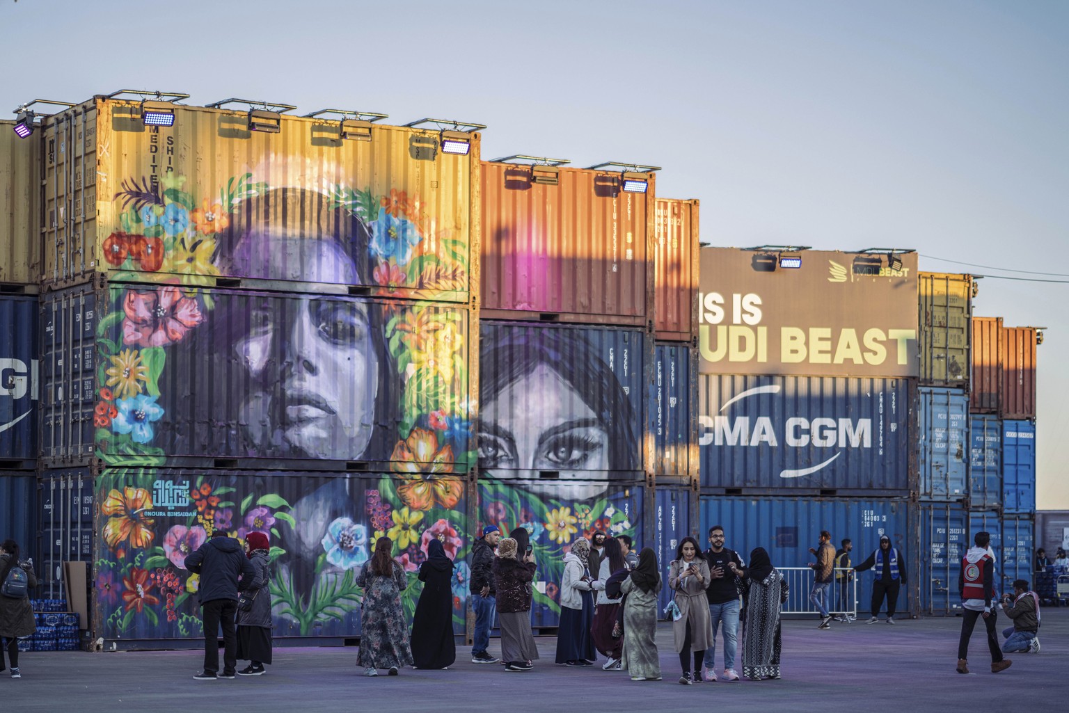 In this Saturday Dec. 21, 2019 photo, people walk behind a concert stage created from shipping containers and painted by local graffiti artists, during the MDL Beast Festival, a three-day musical extr ...