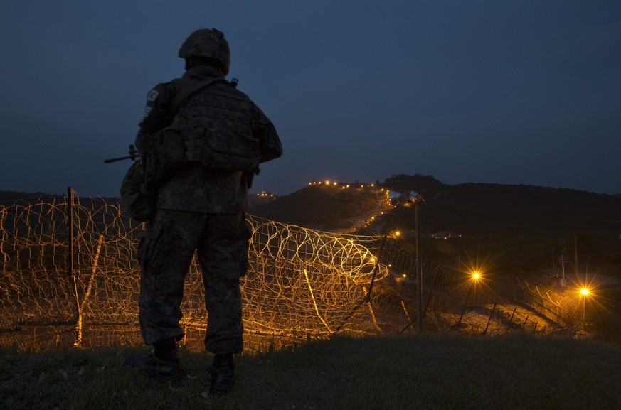 epa04816075 A soldier of South Korean Army&#039;s 6th Division is on night guard duty near a barbed-wire fence inside the Demilitarized Zone (DMZ) separating the two Koreas, at the central section of  ...