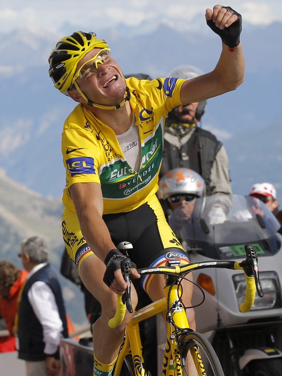 Thomas Voeckler of France clenches his fist as he retains the overall leader&#039;s yellow jersey crossing the finish line on Galibier pass during the 18th stage of the Tour de France cycling race ove ...