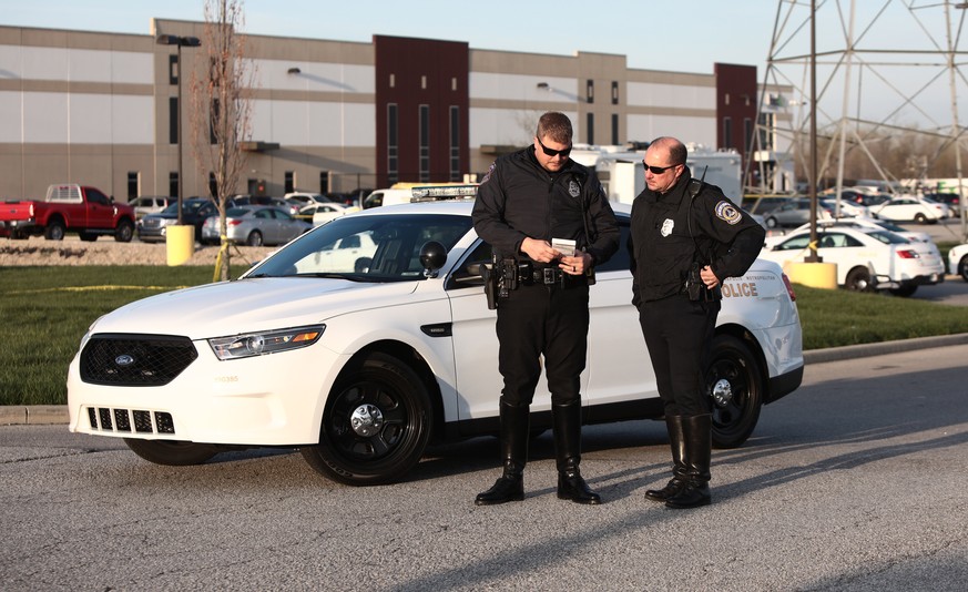 epa09139207 Indianapolis police guard the entrance to a FedEx facilty where a gunman had opened fire, in Indianpolis, Indiana, USA, 16 April 2021. According to police, a gunman has killed at least eig ...