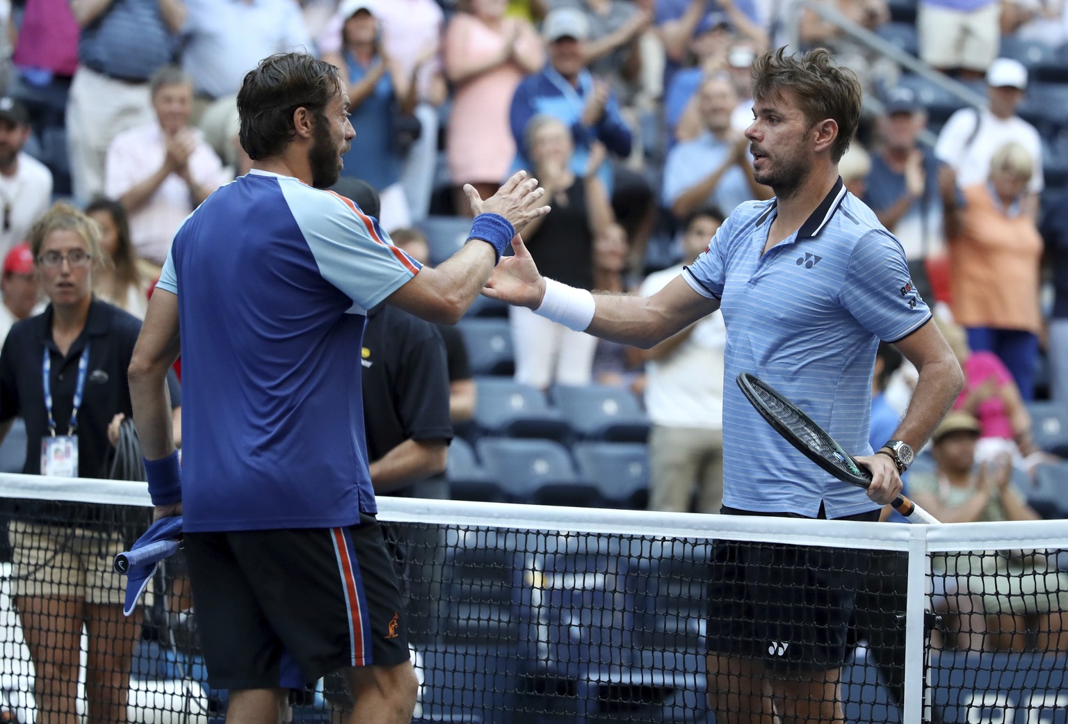 Stan Wawrinka, of Switzerland, shakes hands with Paolo Lorenzi, of Italy, after winning their third-round match of the US Open tennis championships Friday, Aug. 30, 2019, in New York. (AP Photo/Michae ...