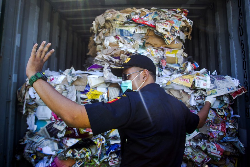 epa07704715 An Indonesian customs official inspects containers loaded with a combination of garbage, plastic waste and hazardous materials from Australia at Tanjung Perak port in Surabaya, East Java,  ...