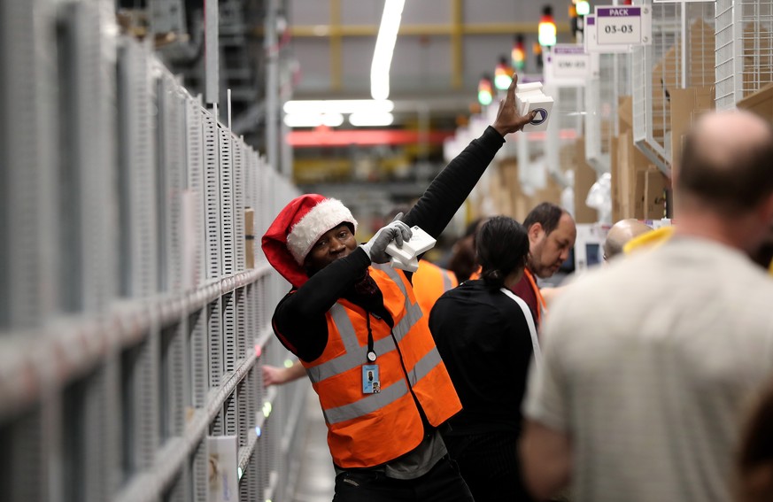 epa08077440 An Amazon employee poses at the Amazon logistic and distribution center in Moenchengladbach, Germany, 17 December 2019. According to the company, Amazon has invested around 105 million eur ...