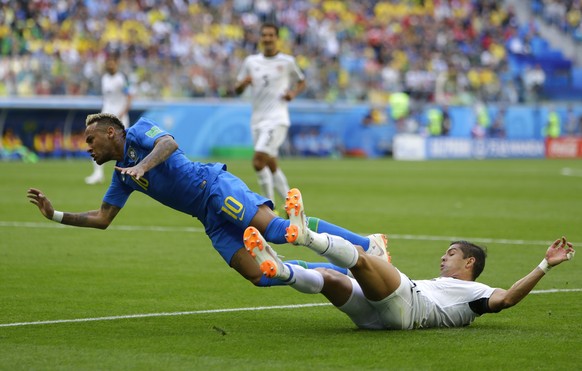 Brazil&#039;s Neymar, left, falls in the tackle of Costa Rica&#039;s Cristian Gamboa during the group E match between Brazil and Costa Rica at the 2018 soccer World Cup in the St. Petersburg Stadium i ...