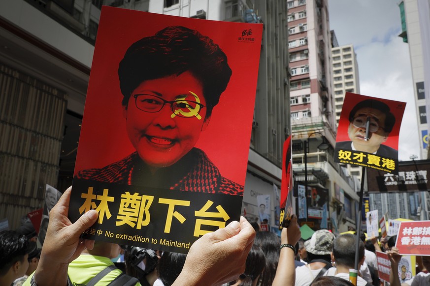 ADDS THAT PLACARD SHOWS HONG KONG&#039;S CHIEF EXECUTIVE CARRIE LAM - A protester with placard showing an image of Hong Kong&#039;s Chief Executive Carrie Lam, marches with others in a rally against t ...