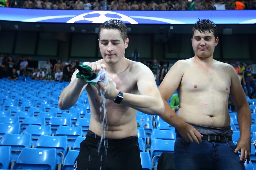 A Borussia Moenchengladbach fan wrings out his shirt as heavy rain falls prior to the start of the Champions League group C soccer match at the Etihad Stadium between Manchester City and Borussia Moen ...