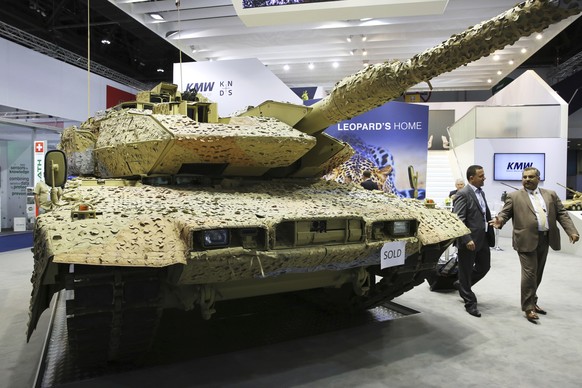 FILE - In this Feb. 22, 2017 file photo, men walk past a German Krauss-Maffei Wegmann Leopard tank with a &quot;sold&quot; sign on it at the International Defense Exhibition in Abu Dhabi, United Arab  ...