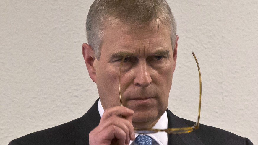 FILE - In this file photo dated Thursday, Jan. 22, 2015, Britain&#039;s Prince Andrew, puts on his glasses prior to his speech to business leaders during a reception at the sideline of the World Econo ...
