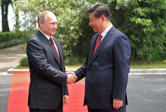 Russia&#039;s President Vladimir Putin, left, and China&#039;s President Xi Jinping shake hands during a welcome ceremony at the Xijiao State Guesthouse ahead of the fourth Conference on Interaction a ...