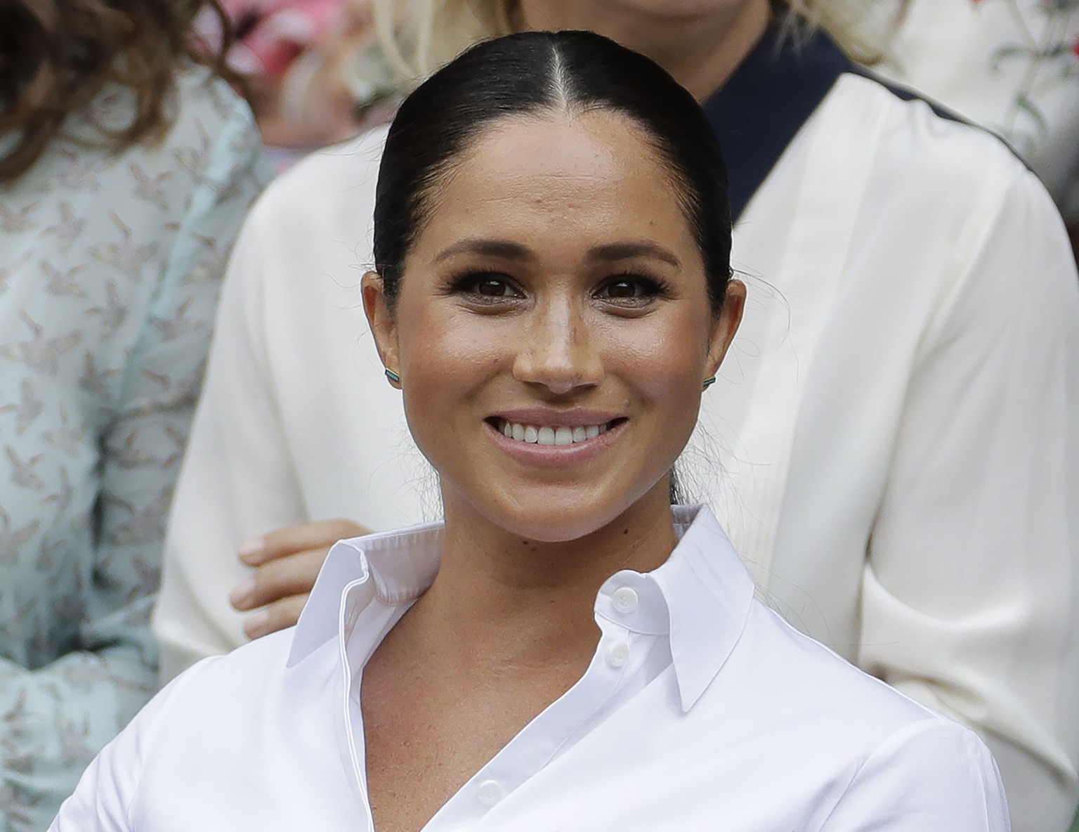 FILE - In this July 13, 2019 file photo, Kate, Meghan, Duchess of Sussex smiles while sitting in the Royal Box on Centre Court to watch the women&#039;s singles final match between Serena Williams, of ...