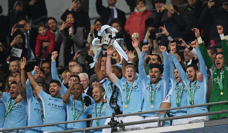 epa06565147 Manchester City players celebrate with the trophy after winning the English League Cup Final between Manchester City and Arsenal FC at Wembley Stadium, London, Britain, 25 February 2018. E ...