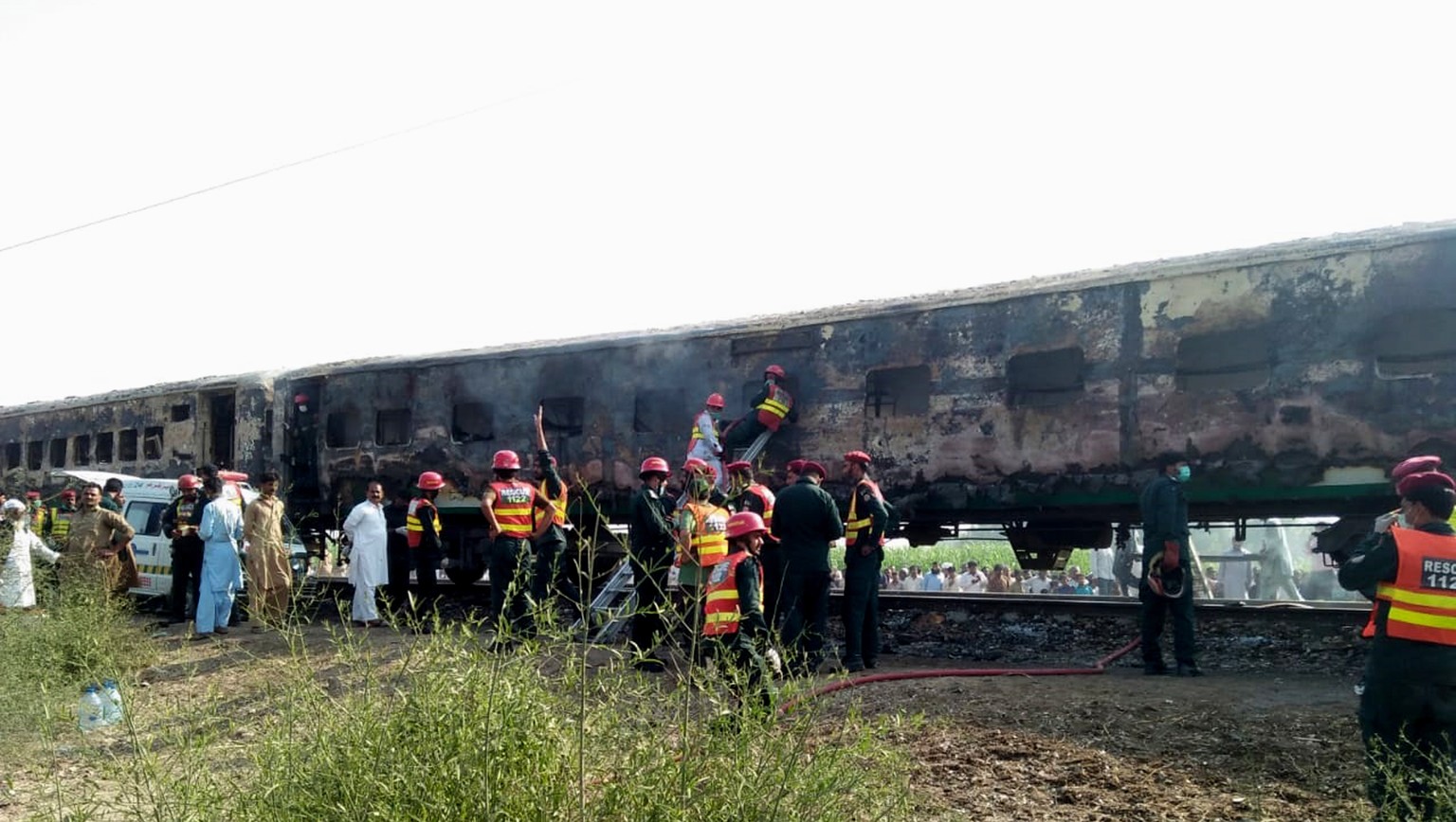 epa07961658 Rescue workers shift the bodies of the victims after a fire engulfed a passenger train near Rahim Yar Khan, Pakistan, 31 October 2019. Dozens were killed and more than 40 others injured af ...