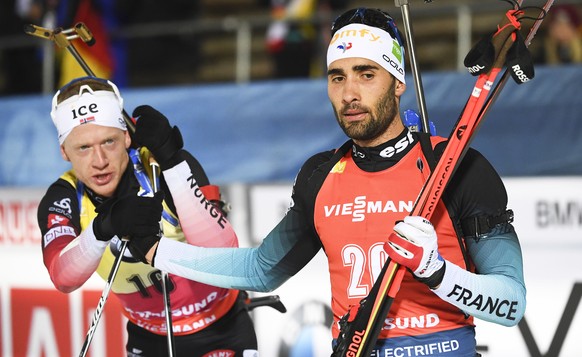epa08044443 Martin Fourcade (R) of France reacts after crossing the finish line during the men&#039;s 20km individual competition of the IBU Biathlon World Cup in Ostersund, Sweden, 04 December 2019.  ...