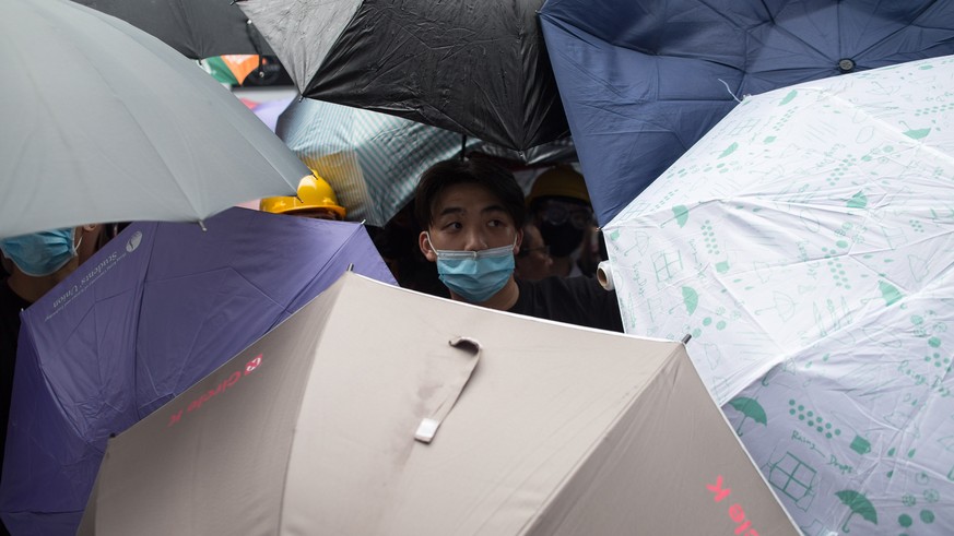 epa07642594 Protesters shelter behind umbrellas during a rally against an extradition bill outside the Legislative Council in Hong Kong, China, 12 June 2019. The bill, scheduled for a second reading o ...