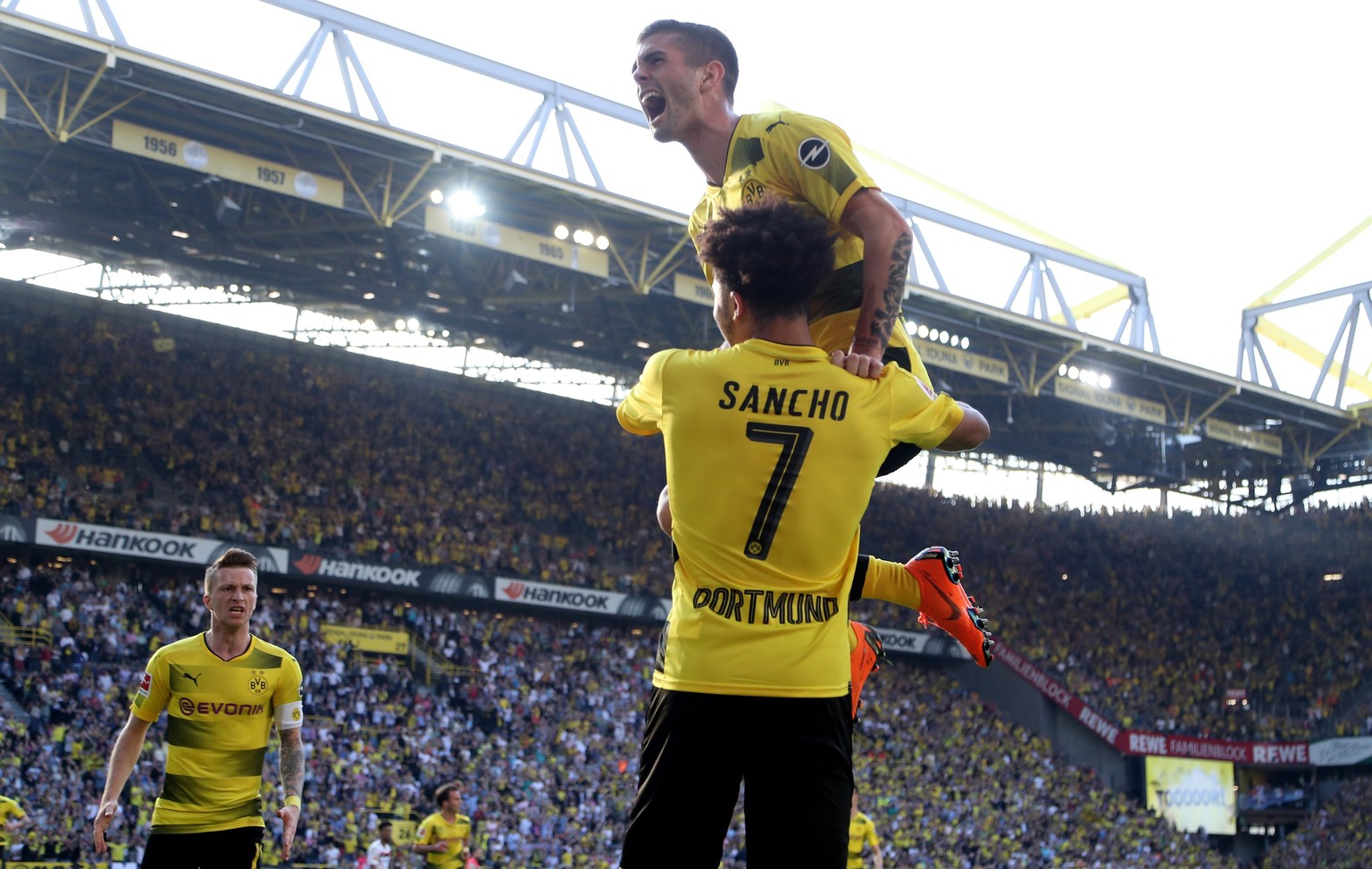 epa06683964 Dortmund&#039;s Jadon Sancho (C) celebrates scoring the opening goal with Dortmund&#039;s Christian Pulisic (R) and Dortmund&#039;s Marco Reus (L) during the German Bundesliga soccer match ...