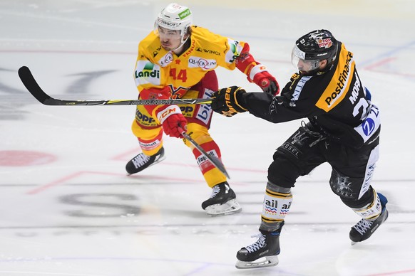 Bienne&#039;s player Samuel Kreis, left, fights for the puck with LuganoÕs player Giovanni Morini, right, during the fourth match of the semifinal of National League Swiss Championship 2017/18 between ...