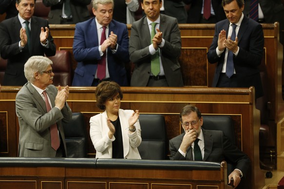 Spain&#039;s Prime Minister Mariano Rajoy, bottom right is applauded by members of his party during the second day of a motion of no confidence session at the Spanish parliament in Madrid, Friday, Jun ...