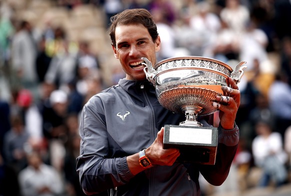 epa07637363 Rafael Nadal of Spain poses with the trophy after winning the men’s final match against Dominic Thiem of Austria during the French Open tennis tournament at Roland Garros in Paris, France, ...