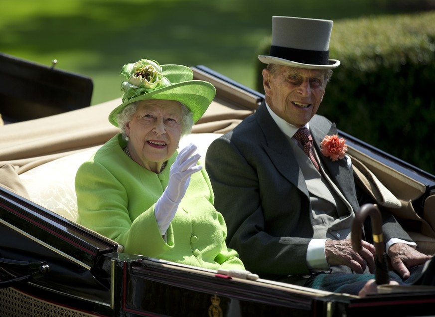 Britain&#039;s Queen Elizabeth II, left, waves to the crowd with Prince Philip at right, as they arrive by open carriage to the parade ring on the first day of the Royal Ascot horse race meeting in As ...