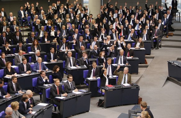 German Chancellor Angela Merkel, bottom left, looks to the faction of the Alternative for Germany, AfD, who demand a change of the procedures during the first meeting of the German parliament after th ...