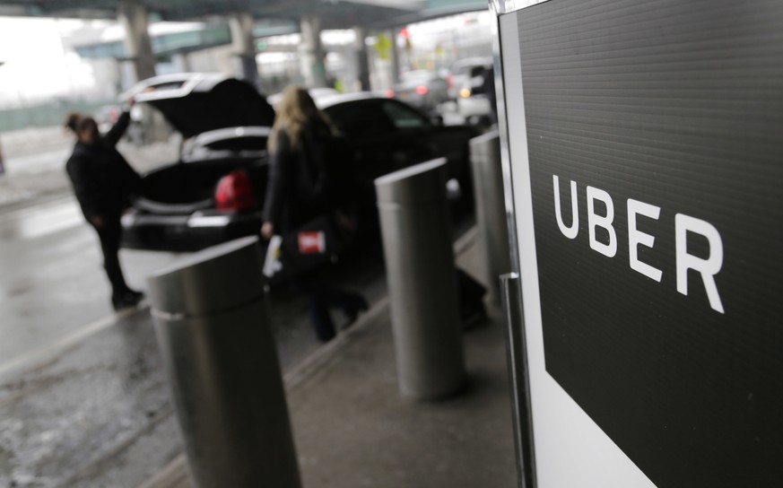 FILE - In this March 15, 2017, file photo, a sign marks a pick-up point for the Uber car service at LaGuardia Airport in New York. Drivers for the ride-hailing company Uber are frustrated over a glitc ...
