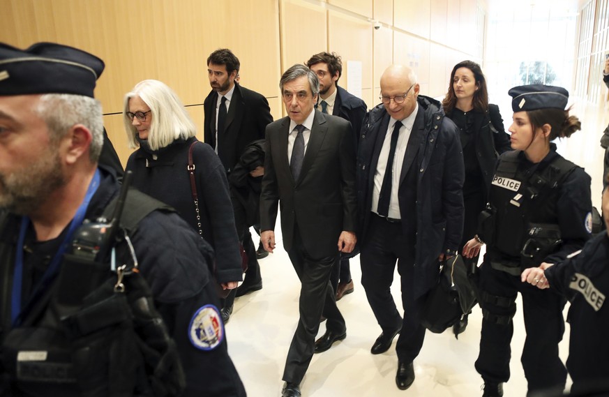 France&#039;s former Prime Minister Francois Fillon, center, and his wife Penelope, leave the Paris courthouse, in Paris, Monday, Feb. 24, 2020. He could have been president of France. Instead, former ...