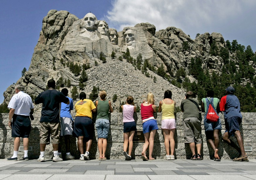 FILE - In this July 21, 2005 file photo, visitors watch while workers pressure wash the granite faces of George Washington, left, Thomas Jefferson, Theodore Roosevelt and Abraham Lincoln at Mount Rush ...